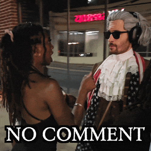 a man in a wig is talking to a woman in front of a no comment sign