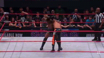 two wrestlers are wrestling in a ring with a referee watching .