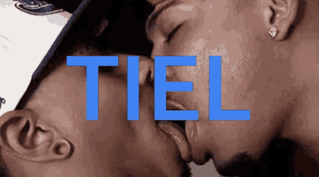 a man kissing another man with the word tiel above them