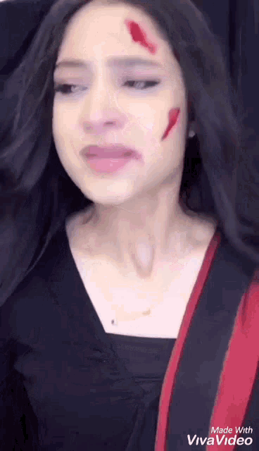 a woman with blood on her face is crying and made with viva video