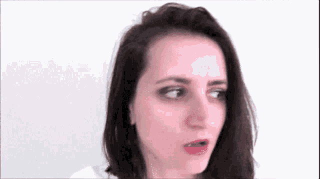 a close up of a woman 's face with a surprised expression on her face .