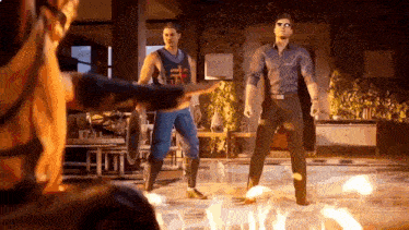 two men are standing next to each other in a room with fire coming out of the ground .