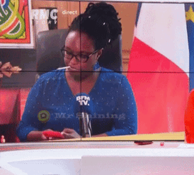 a woman sitting in front of a rmc tv
