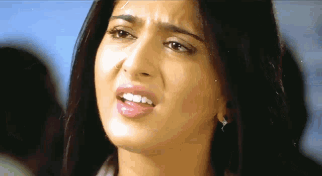 a close up of a woman 's face with her mouth open