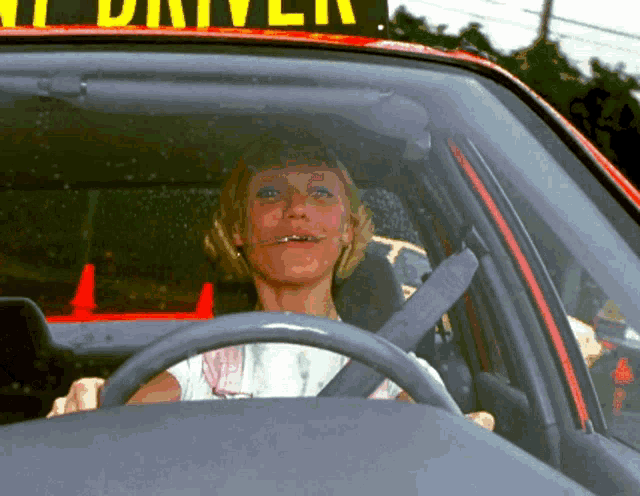 a woman is sitting in a car under a sign that says " taxi driver "