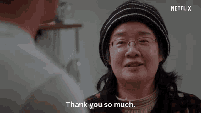 a woman with glasses says thank you so much in front of a netflix logo