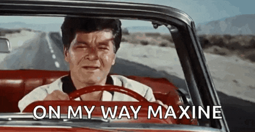 a man is crying while driving a red car and the words `` on my way maxine '' are written on the screen .