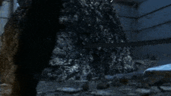 a person is standing in a dark cave with a glowing light coming out of the ceiling .