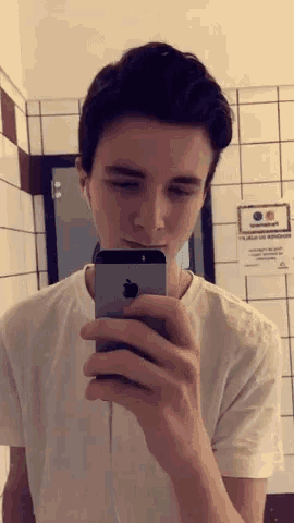 a young man is taking a selfie with an apple iphone