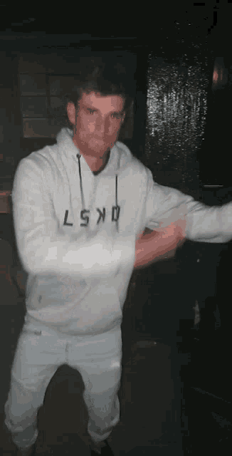 a man wearing a white hoodie that says lsxd on it
