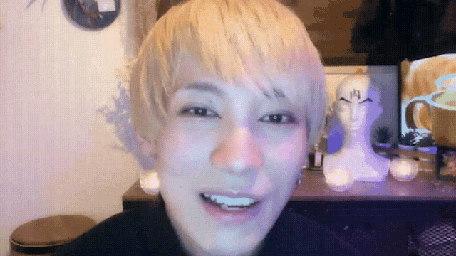 a man with blonde hair is smiling and looking at the camera