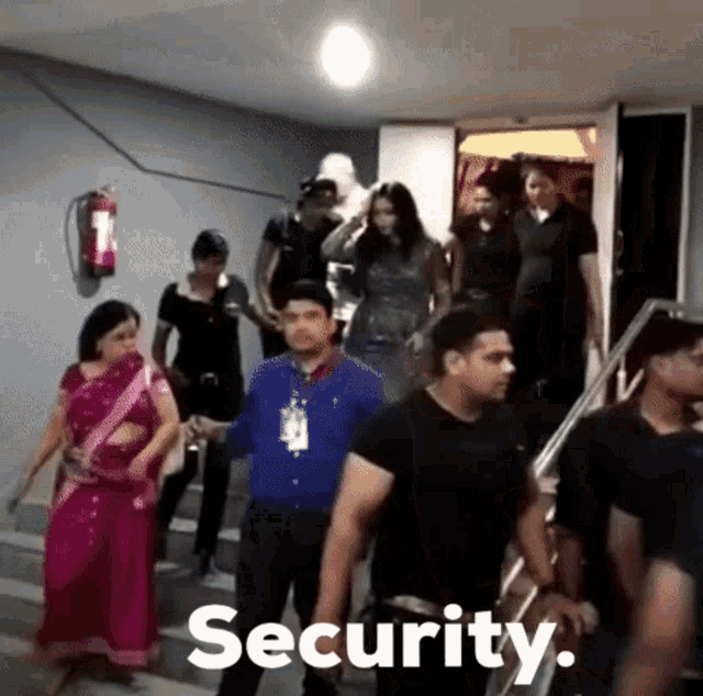 a group of people are walking down stairs and the word security is on the bottom of the image