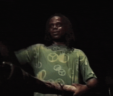 a man wearing a green shirt with a peace sign on it