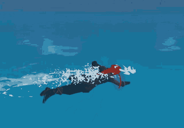 a man in a red hat is swimming in a blue ocean