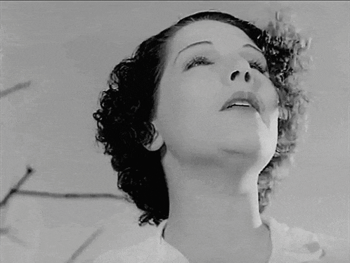 a black and white photo of a woman looking up