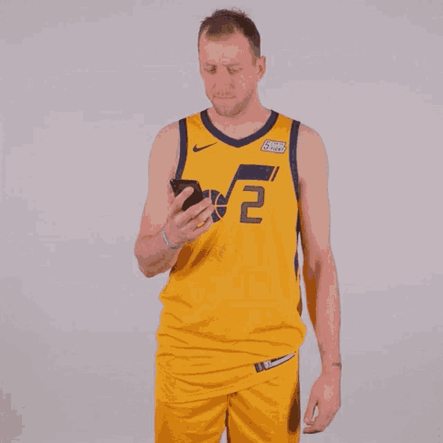 a basketball player wearing a yellow jersey with the number 2 on it