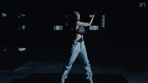 a woman wearing gloves and a crop top with the letter s on the bottom right