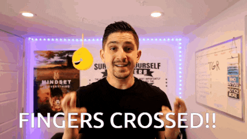 a man says fingers crossed while standing in front of a mindset poster
