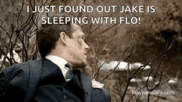 a man in a suit and tie is sleeping in a tree with a caption .