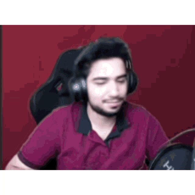 a man wearing headphones is sitting in a chair in front of a microphone .