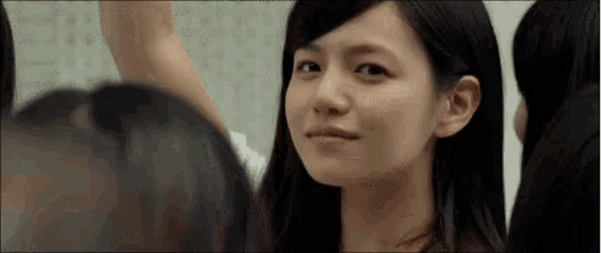 a woman with long black hair is smiling and looking at the camera