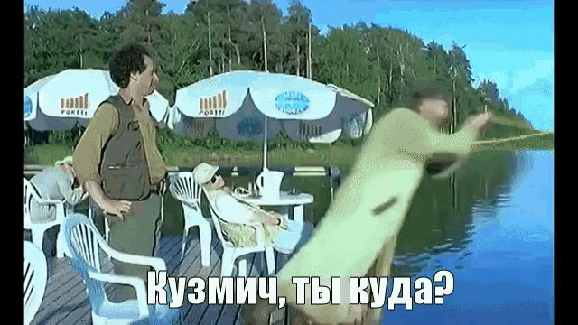 a man standing on a dock talking to another man while a woman sits on a chair in the background