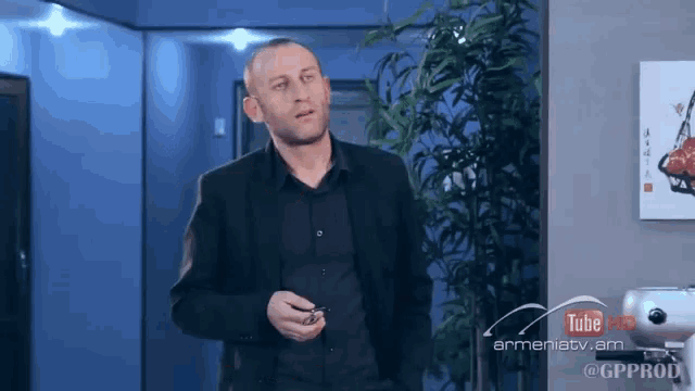 a man in a suit stands in front of a sign that says youtube hd