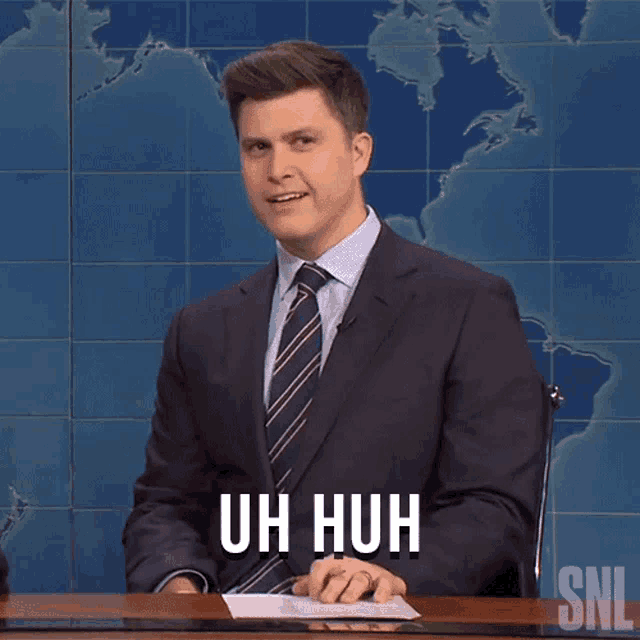 a man in a suit and tie says " uh huh "
