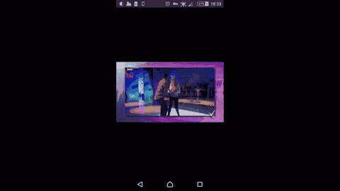 a phone screen shows a video of a man dancing on a stage