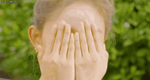 a woman covering her face with her hands and the word nacific is visible