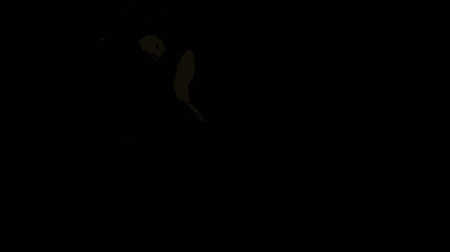 a man in a light blue shirt is looking down at something