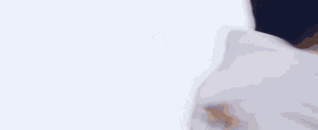 a man in a white shirt is standing in front of a white background and looking at something .