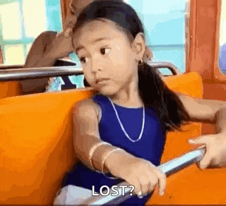a little girl is sitting on a roller coaster and looking at the camera .