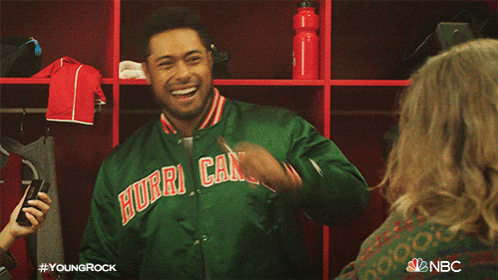 a man in a bomber jacket is talking to a woman in a locker room .