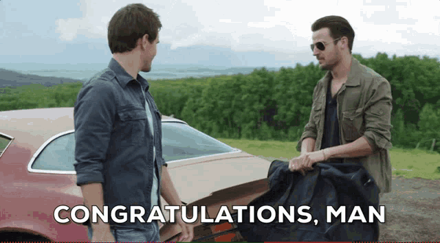 two men standing in front of a car with the words congratulations man