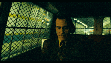 a man in a suit and tie sits in the back of a van