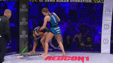 two women are fighting in a ring with the words redcon1 on the floor