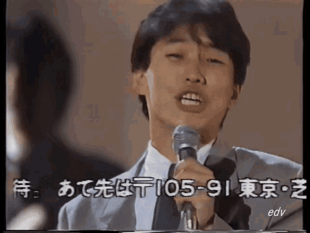 a man singing into a microphone with edv written on the bottom