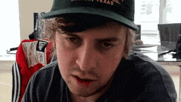 a man wearing a green hat that says texas