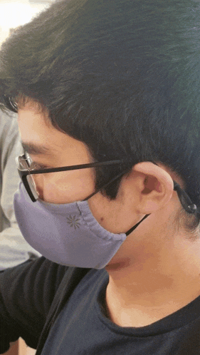 a man wearing glasses and a purple mask