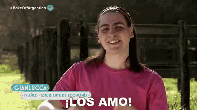 a girl in a pink shirt says los amo in spanish
