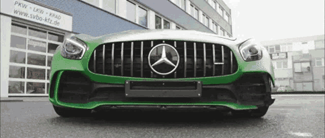 a green mercedes is parked in front of a building that says pkw