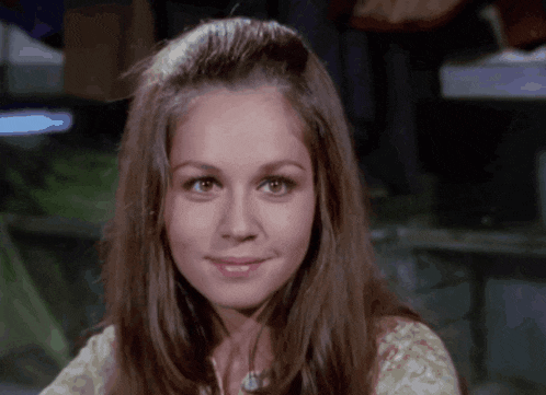 a close up of a woman 's face with long brown hair