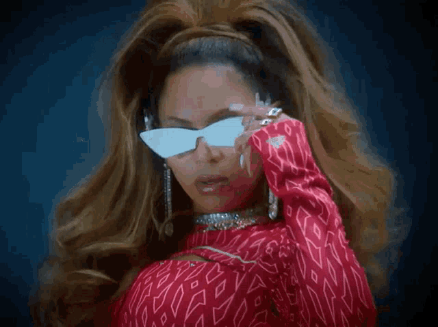 a woman wearing a red top and white sunglasses