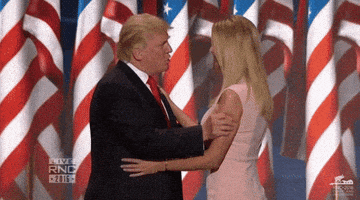 a man and a woman are hugging in front of american flags