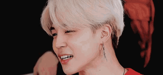 a close up of a person 's face with blonde hair and silver earrings
