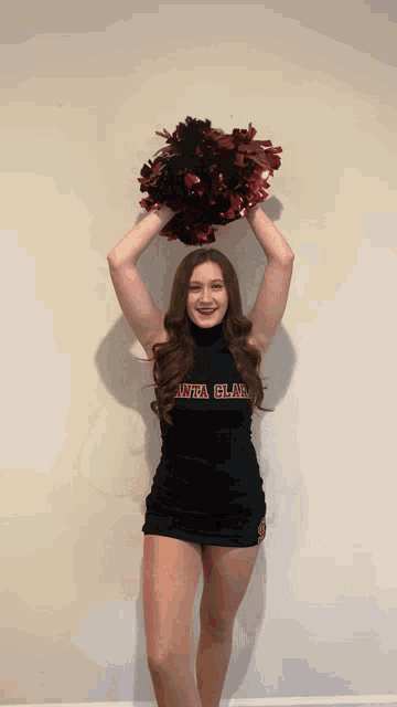 a cheerleader wearing a black sweater that says uva clae