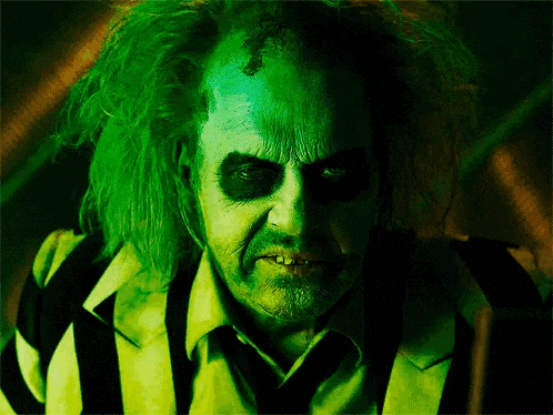 a man with green hair and black eyes is wearing a striped shirt and tie .