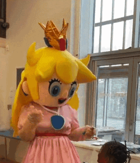 a princess peach mascot with a crown on her head