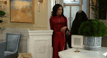 a woman in a red jumpsuit is standing next to a woman in a black jumpsuit .